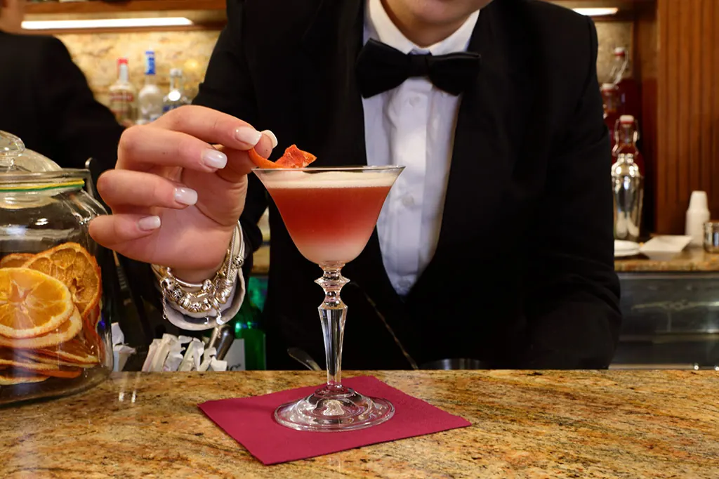 Il barman di Ceraldi Caffè guarnisce un cocktail al bancone